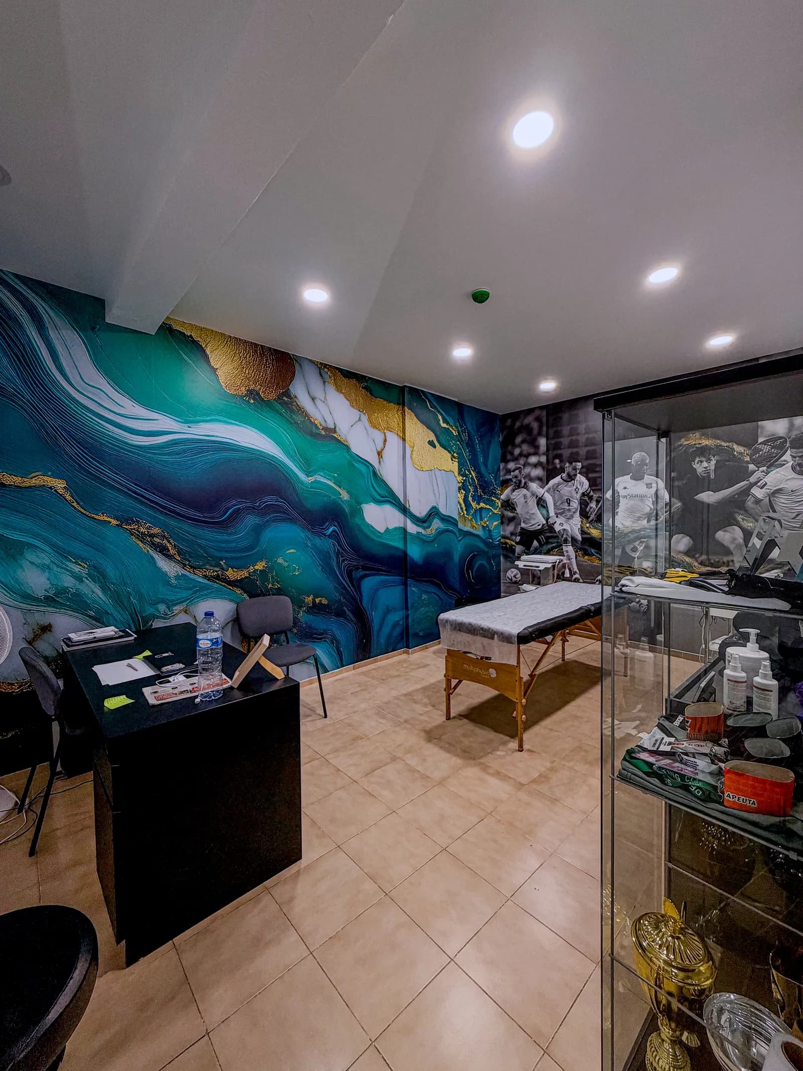 Sala de tratamento com mural em tons de azul e dourado
