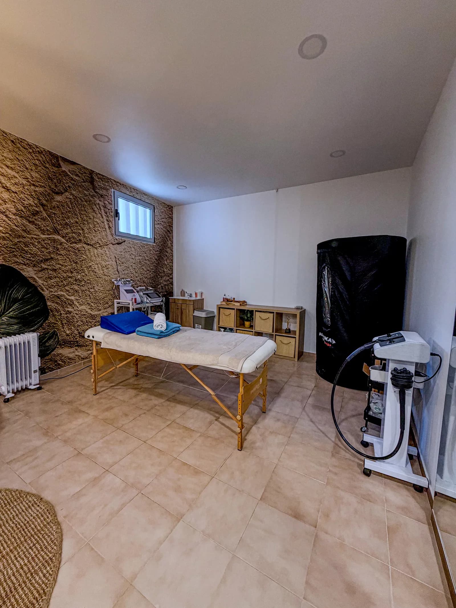 Sala de tratamento com parede de pedra e marquesa