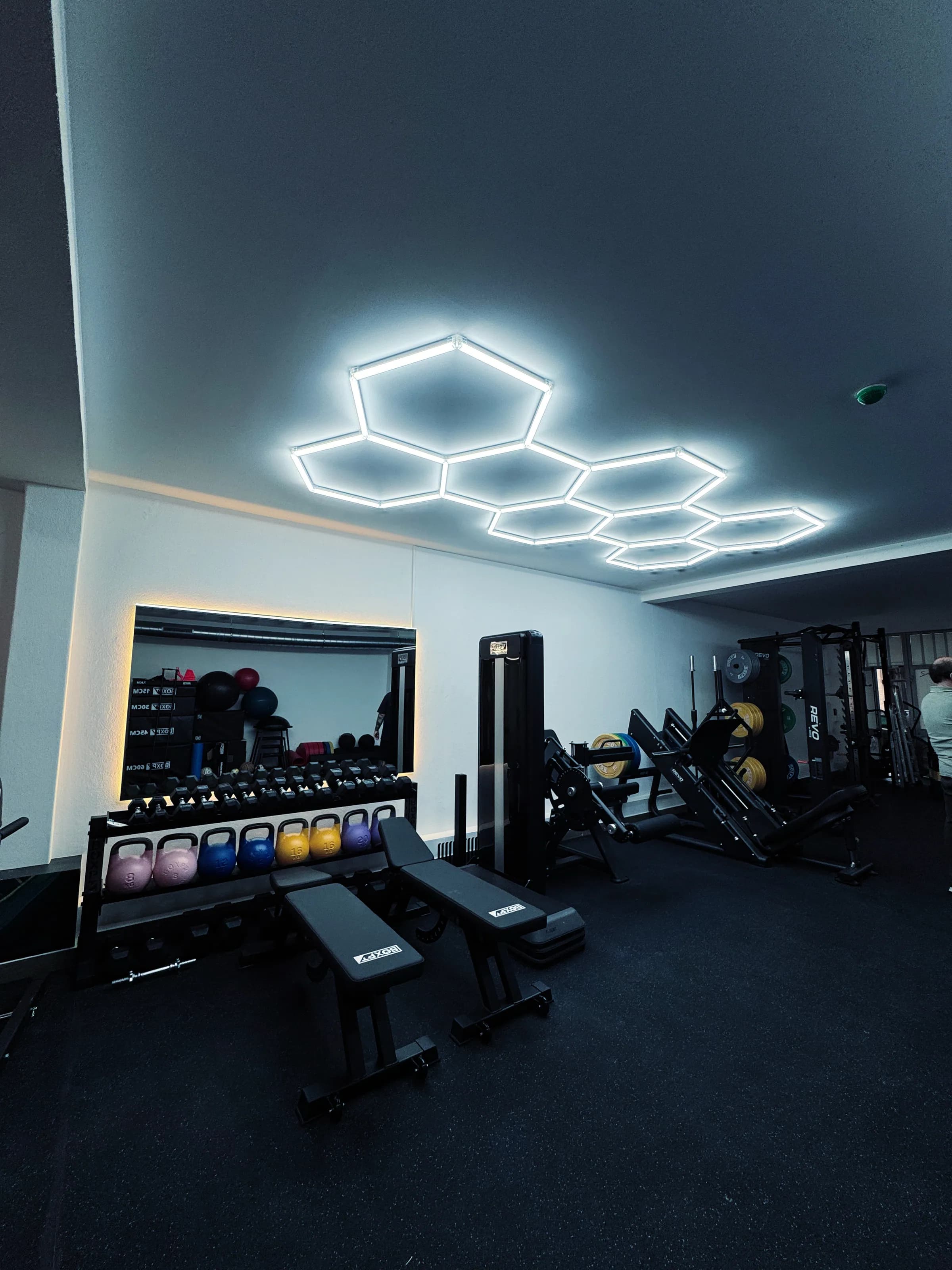 Ginásio de reabilitação da Fisio4you, com máquinas de força e iluminação hexagonal